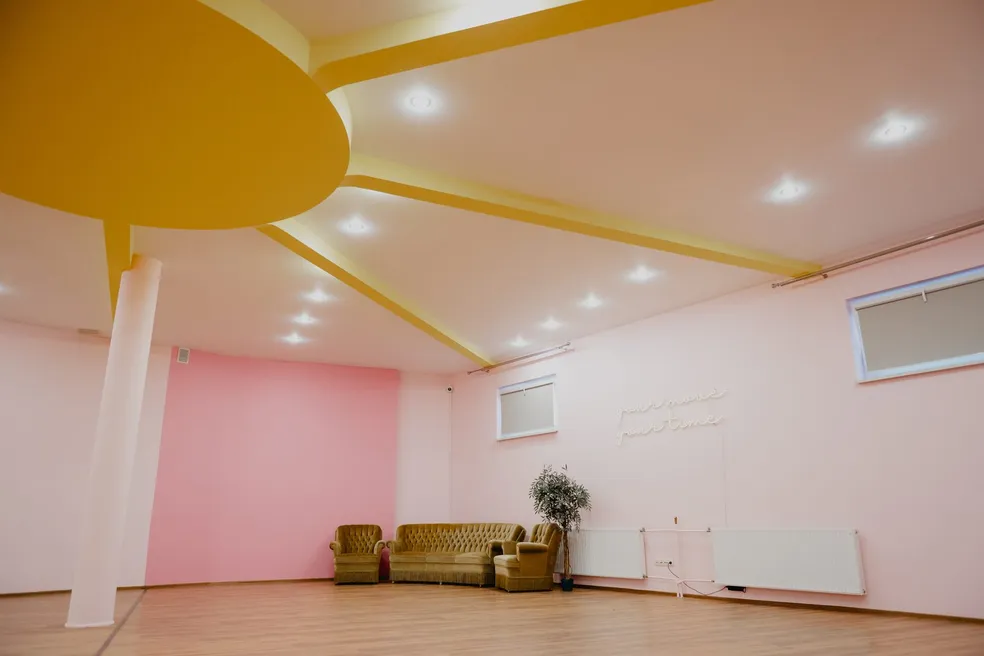 Sala Dzień w Your Move Dance Studio — jasnoróżowa ściana i żółte słońce na suficie